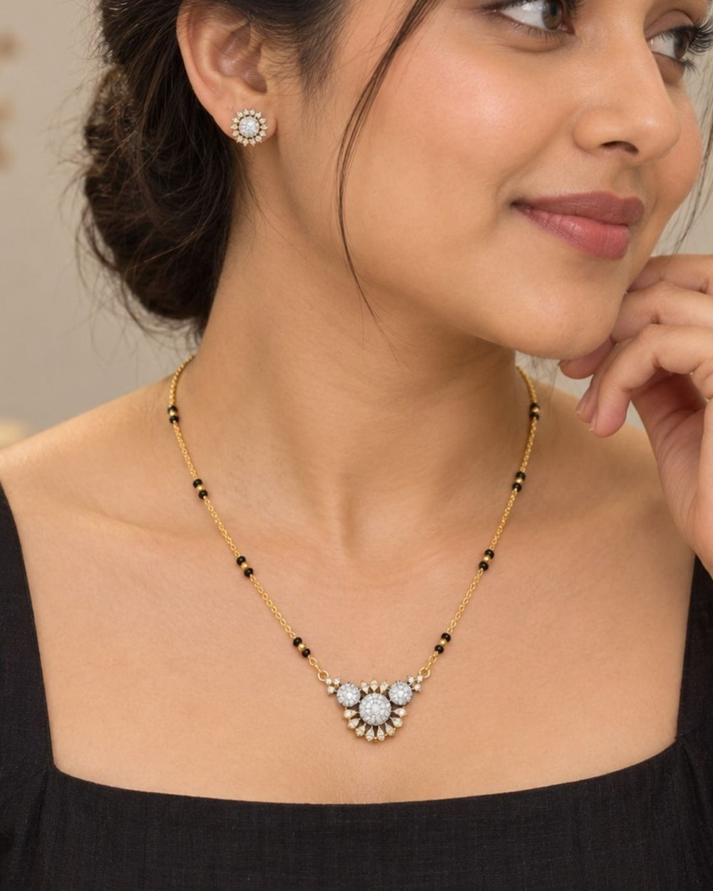 Stylish gold plated necklace set featuring a delicate black beaded chain, sparkling zircon diamond floral pendant, and matching sun-inspired stud earrings, perfect for everyday and festive wear.