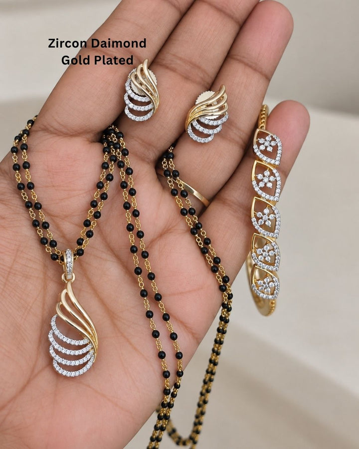 Designer gold plated mangalsutra set for women featuring black bead strands, sparkling zircon detailing, an elegant curved pendant, matching earrings, and bracelet, perfect for everyday and traditional wear.