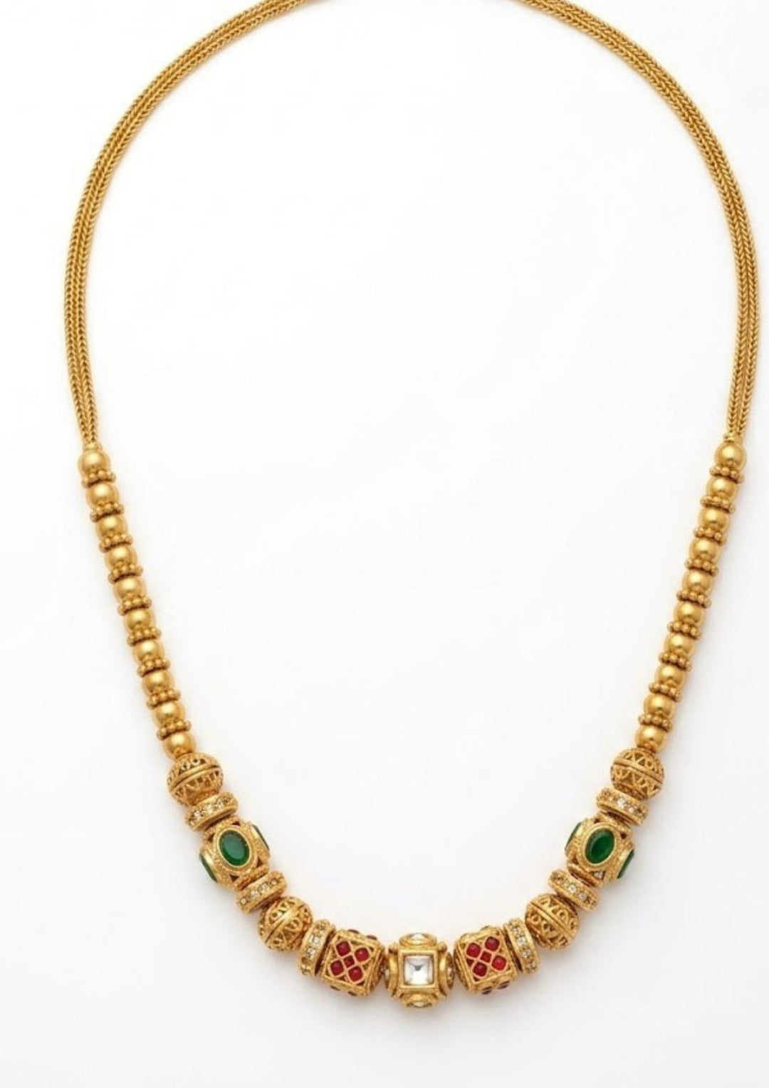 Antique Gold Plated Beads Mala with long traditional chain designed with gold beads , antique finish pattern, and South Indian jewelry style. The mala comes with kundans and green and red stones in cube pattern and balls pattern with green stones . this is sweat proof quality, anti-fade colour, skin-friendly finish, and is suitable for pooja functions, festivals, daily wear, and traditional occasions.
