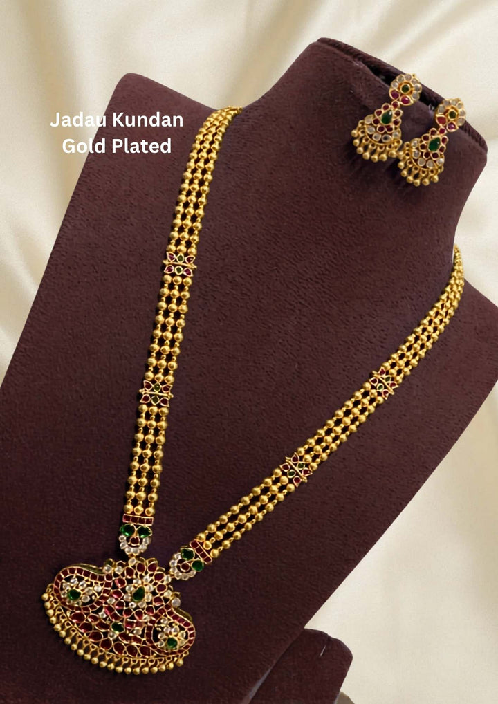 Gold-plated necklace set with intricate design long necklace Setand earrings  with green and red stones come with jadau kundan in necklace set  with beads and in pendent and earrings shows clear design and in detailed shown in picture it will not fade color and water proof can used for festivals, bridals, and weeding's  