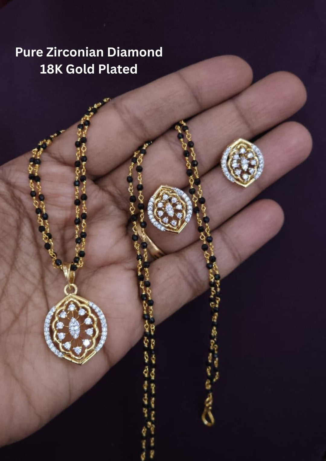 Gold and black jewelry set including necklace, pendant, and earrings