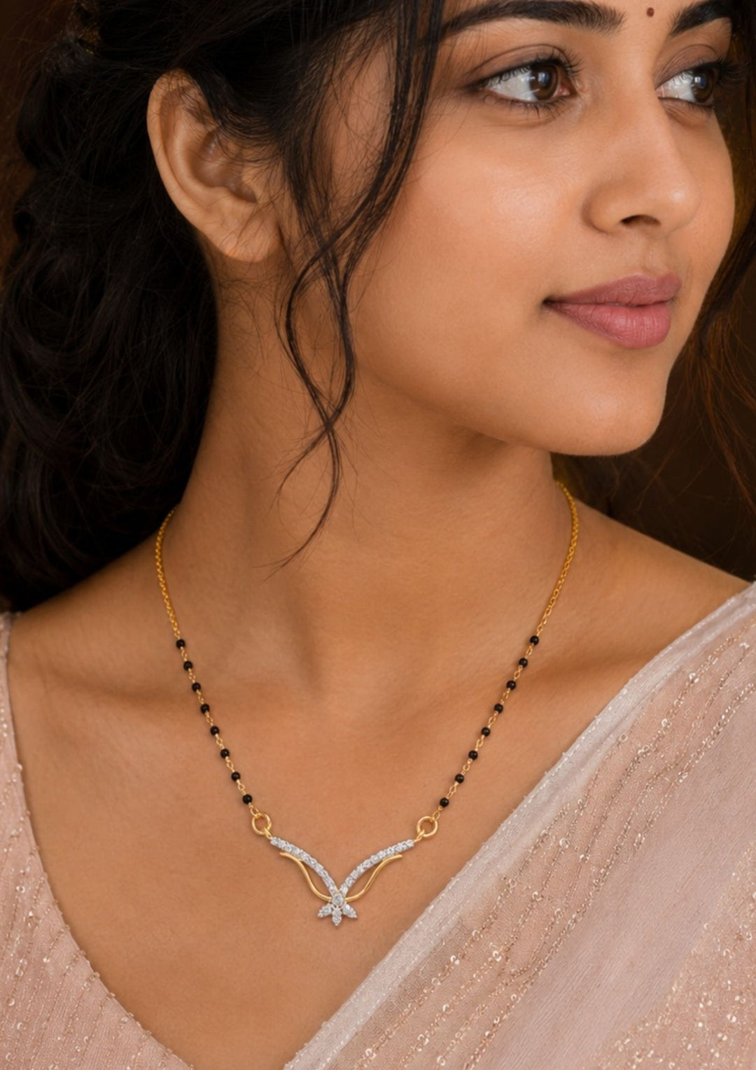 South Indian Woman wearing Gold plated black beads mangalsutra featuring an elegant butterfly-inspired zircon centerpiece with delicate curved detailing. Lightweight and beautifully crafted for everyday elegance, festive occasions, and gifting.