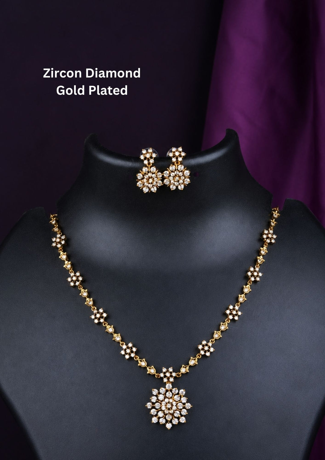 Zircon diamond gold-plated necklace set showcasing an intricate chain linked with tiny floral stone clusters and a beautiful geometric snowflake statement pendant. The matching earrings perfectly mirror the pendant's starburst design, beautifully showcased on a minimalist matte black display bust against a dark backdrop.