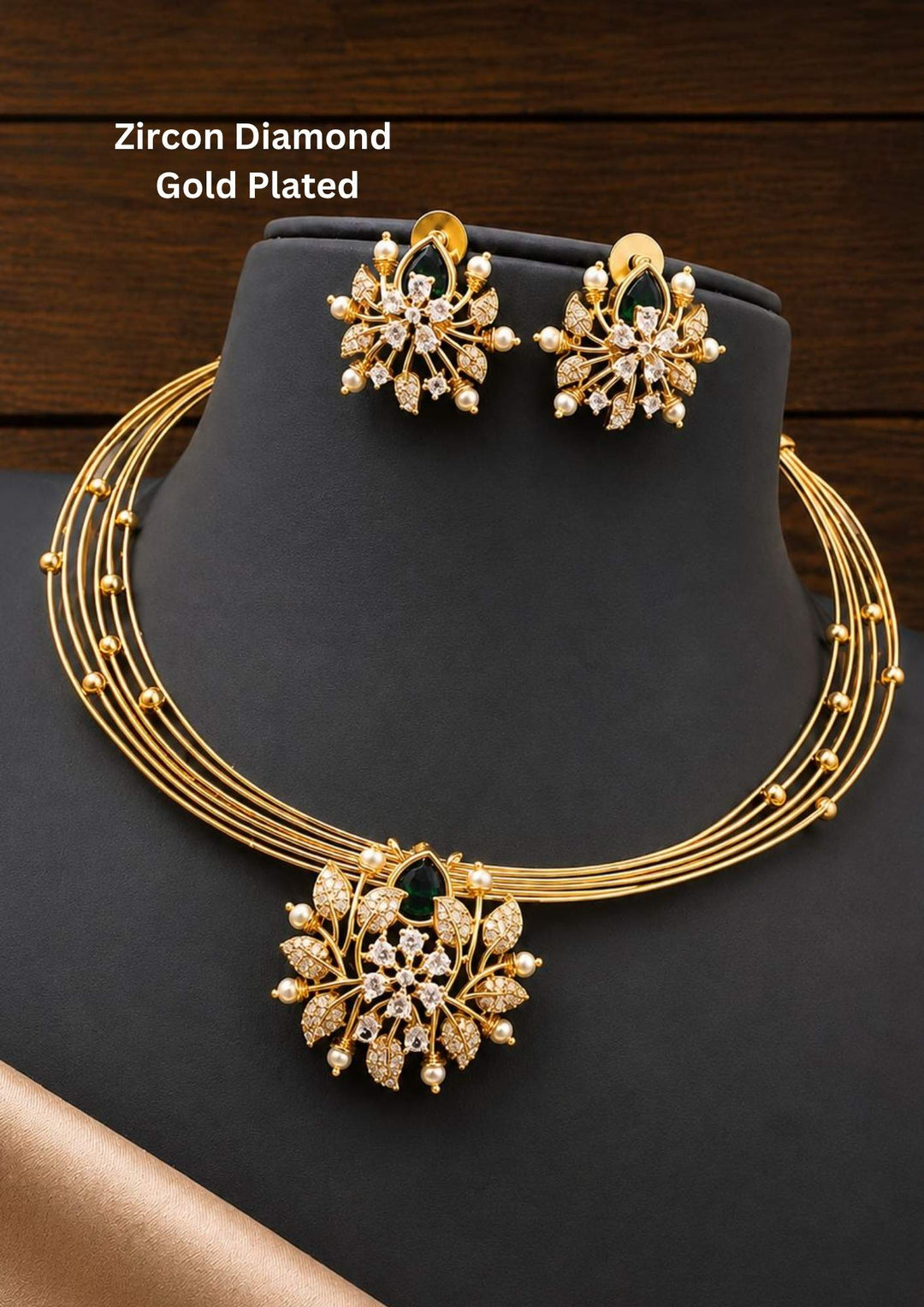 zircon diamond gold plated necklace with earrings designed with white pearls and leaf shaped gold beads with green emerald stone in middle. This necklace set has a premium gold finish, is lightweight, and comfortable to wear. Suitable for daily use, pooja, weddings, festivals, functions, and family occasions. It is sweat-proof, anti-fade, skin-friendly, and easy to wear daily