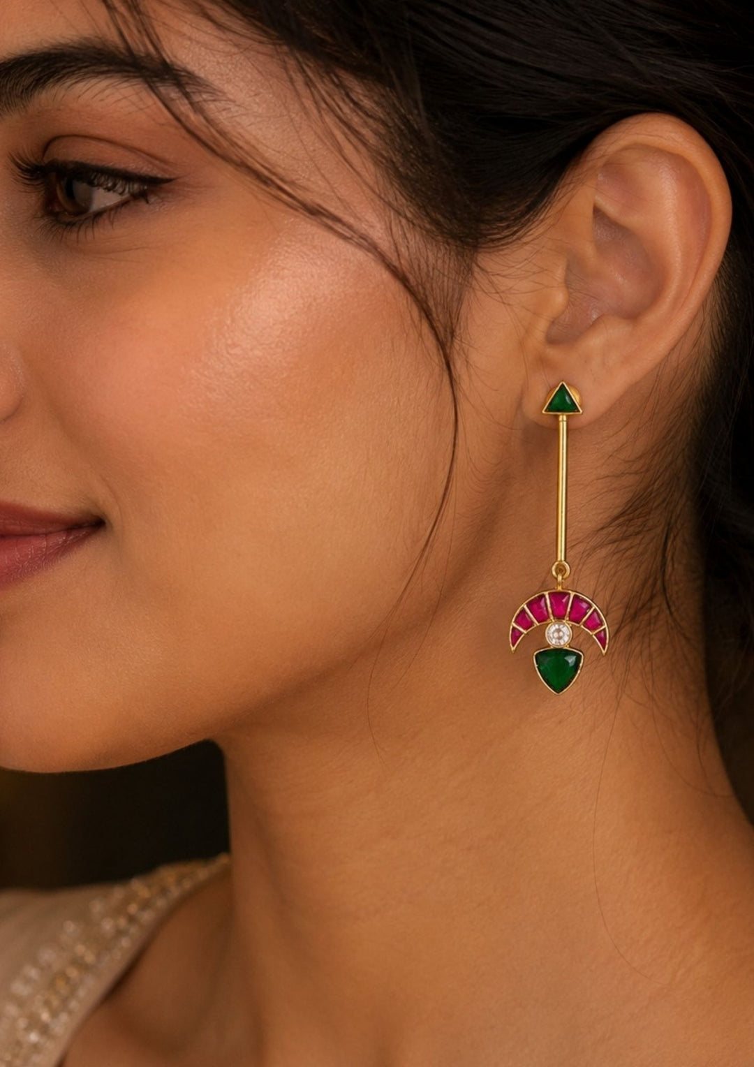 Close up view of south indian women wearing Gold plated long real kemp earrings designed in half moon shape with long bar and up stud designed in triangle shape come with lightweight perfect for weddings, functions, giftings, office wear and it is anti tarnish and skin friendly