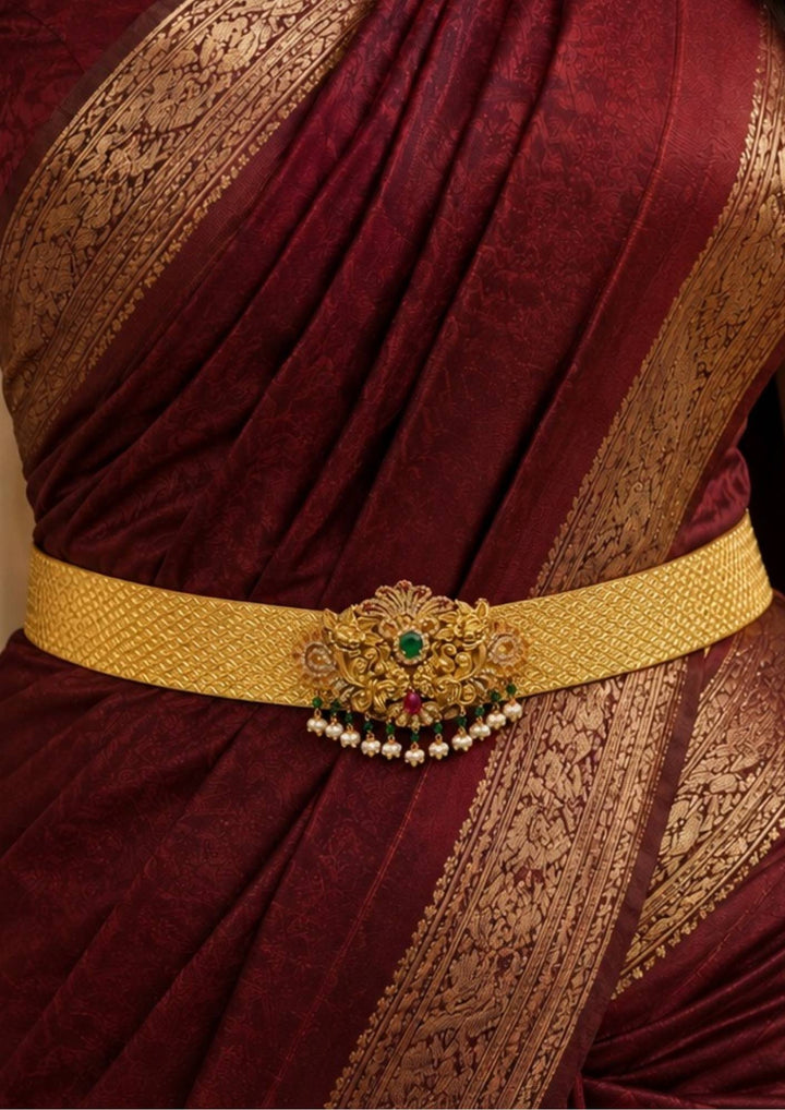 A close up view of South Indian Women wearing Gold Plated Twin Peacock adults hipbelt designed with pearl drops and lotus with emerald in center perfect for weddings, bidal wear, function and it is anti tarnish