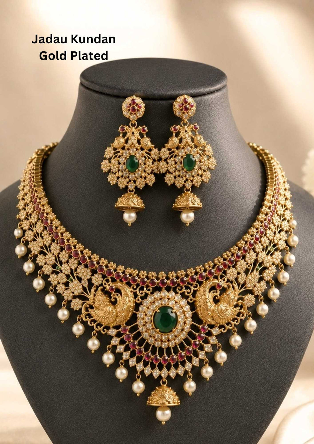 Gold pleted jadau kundan chocker set designed with twin peackocks and in center big emerald stone and bottom comes with bell and pearls to entire chocker and this set comes with matching big earrings perfect for birdal wear, functions