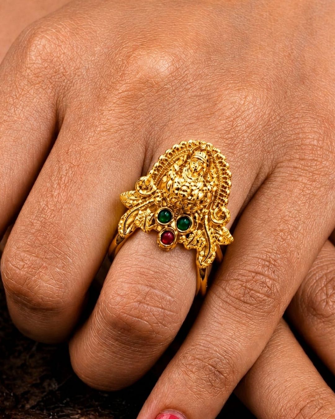Beautiful Lakshmi Devi gold plated ring featuring an intricate goddess motif, green and ruby-colored stone detailing, and an ornate traditional finish. Perfect for festive occasions, temple visits, traditional outfits, and gifting.