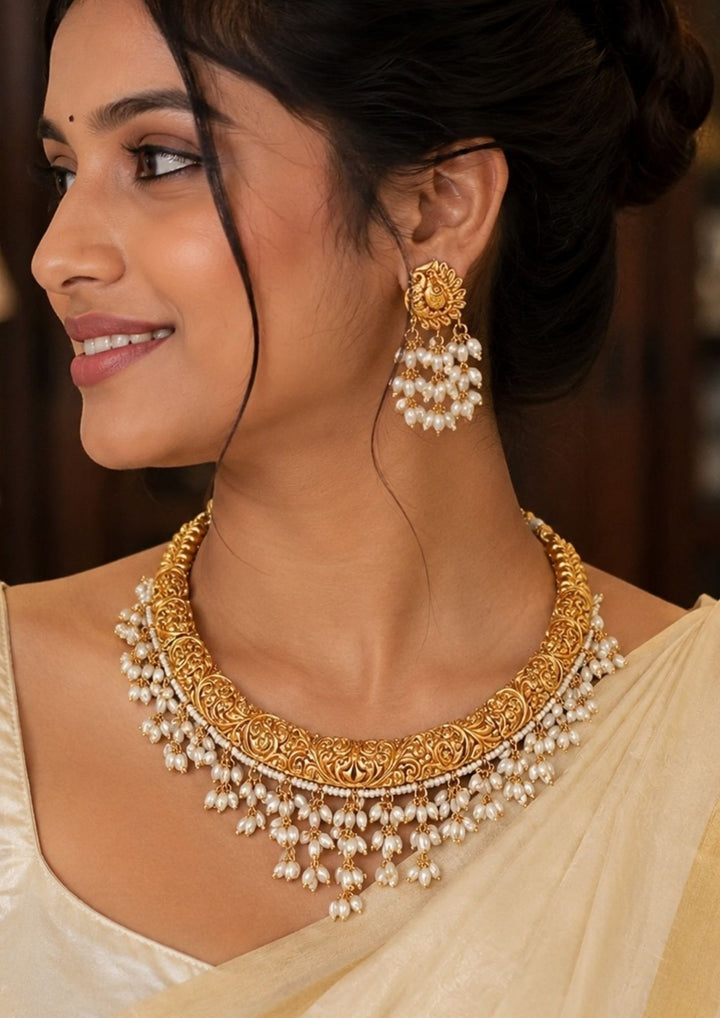 South Indian Woman wearing a Guttapusalu gold plated necklace set with matching earrings designed with traditional rice bead pearls , gold plated finish, and earrings designed in peacock shape, lightweight comfortable wear, perfect for weddings, festivals, poojas.