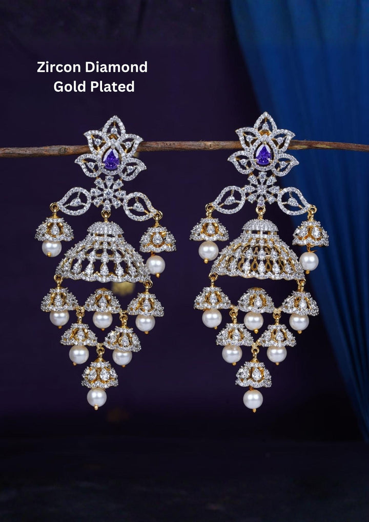 Gold-plated zircon diamond finish multi-tier jhumka earrings designed with dazzling CZ crystals, with a purple tear-drop accent stone, and delicate hanging white pearls that give a graceful traditional and modern look for receptions, sangeet, luxury weddings, and party wear styling with lightweight comfortable use and COD available now.