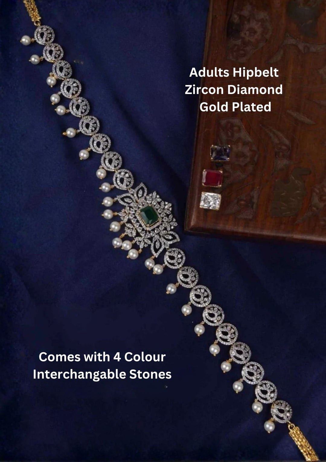 A premium gold plated adult hipbelt (vaddanam) encrusted with shimmering zircon diamonds and a delicate lower fringe of dangling white pearls. The center features a prominent rectangular emerald stone, showcased alongside its three interchangeable alternative gemstone inserts in ruby red, amethyst purple, and clear white diamond crystal.