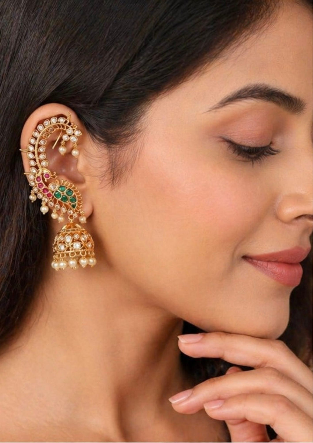 Close-up of a south indian woman wearing an Grand festive style 18k gold plated Jadau Kundan full ear cuffs with green and pink peacock detailing and hanging jhumkas. This traditional Indian bridal ear accessory offers a heavy, royal look that pairs perfectly with wedding lehengas, silk sarees, and festive wear.