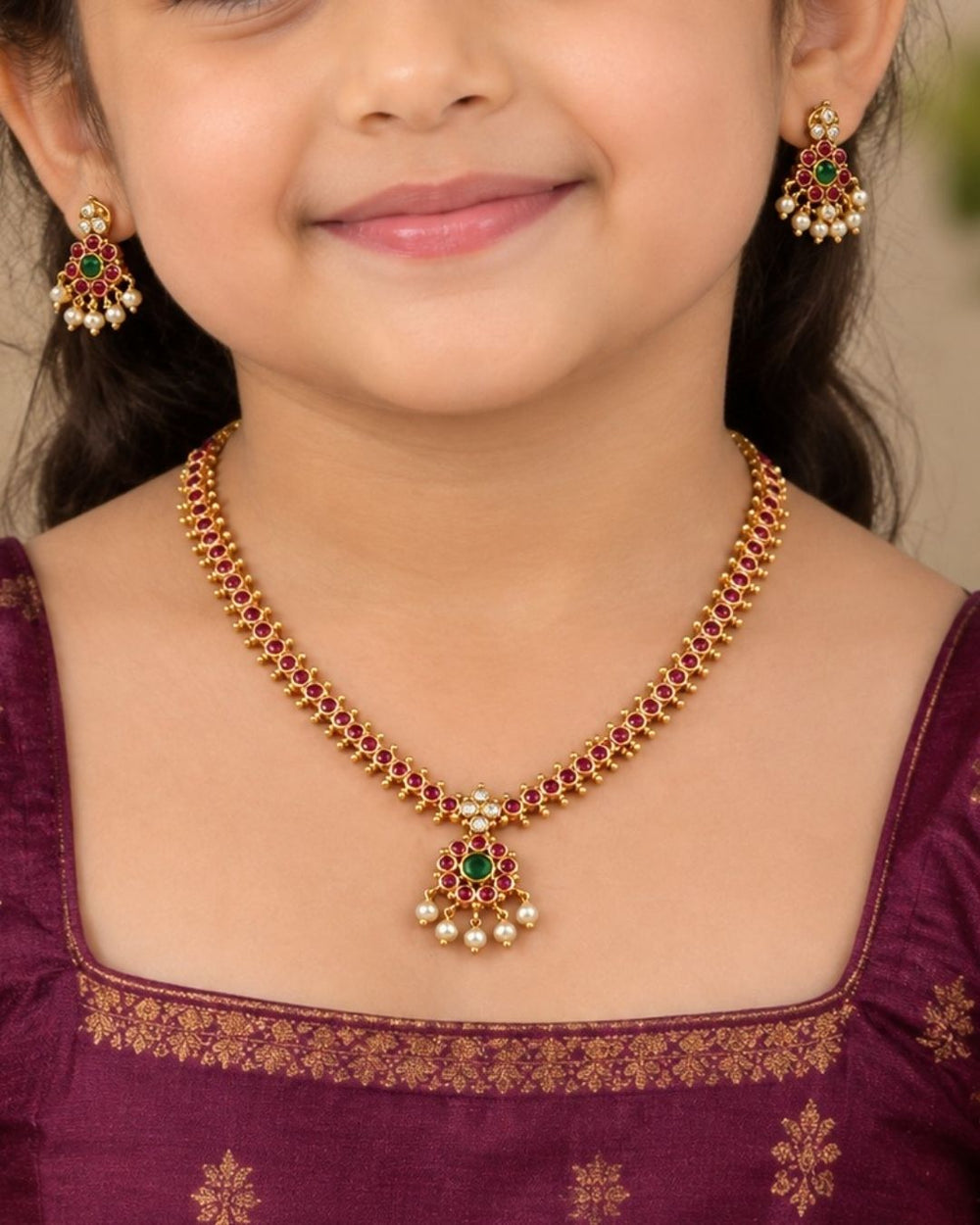 Beautiful Jadau Kundan gold plated necklace set featuring a ruby and green stone design, detailed Kundan work, and delicate pearl drops. Perfect for festive occasions, traditional outfits, weddings, parties, and gifting.