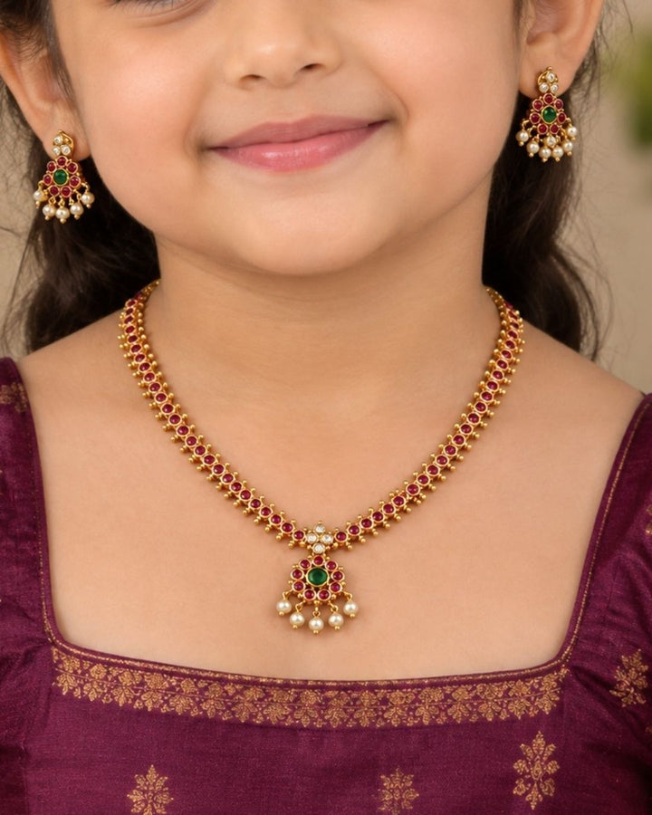Beautiful Jadau Kundan gold plated necklace set featuring a ruby and green stone design, detailed Kundan work, and delicate pearl drops. Perfect for festive occasions, traditional outfits, weddings, parties, and gifting.