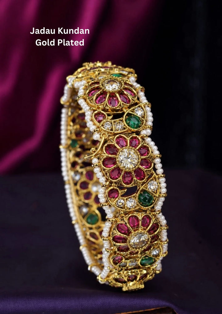 Beautiful Jadau Kundan gold plated floral kada featuring ruby and green stones, dazzling kundan work, intricate craftsmanship, and pearl borders. Perfect for weddings, festivals, temple visits, traditional attire, special occasions, and premium gifting.