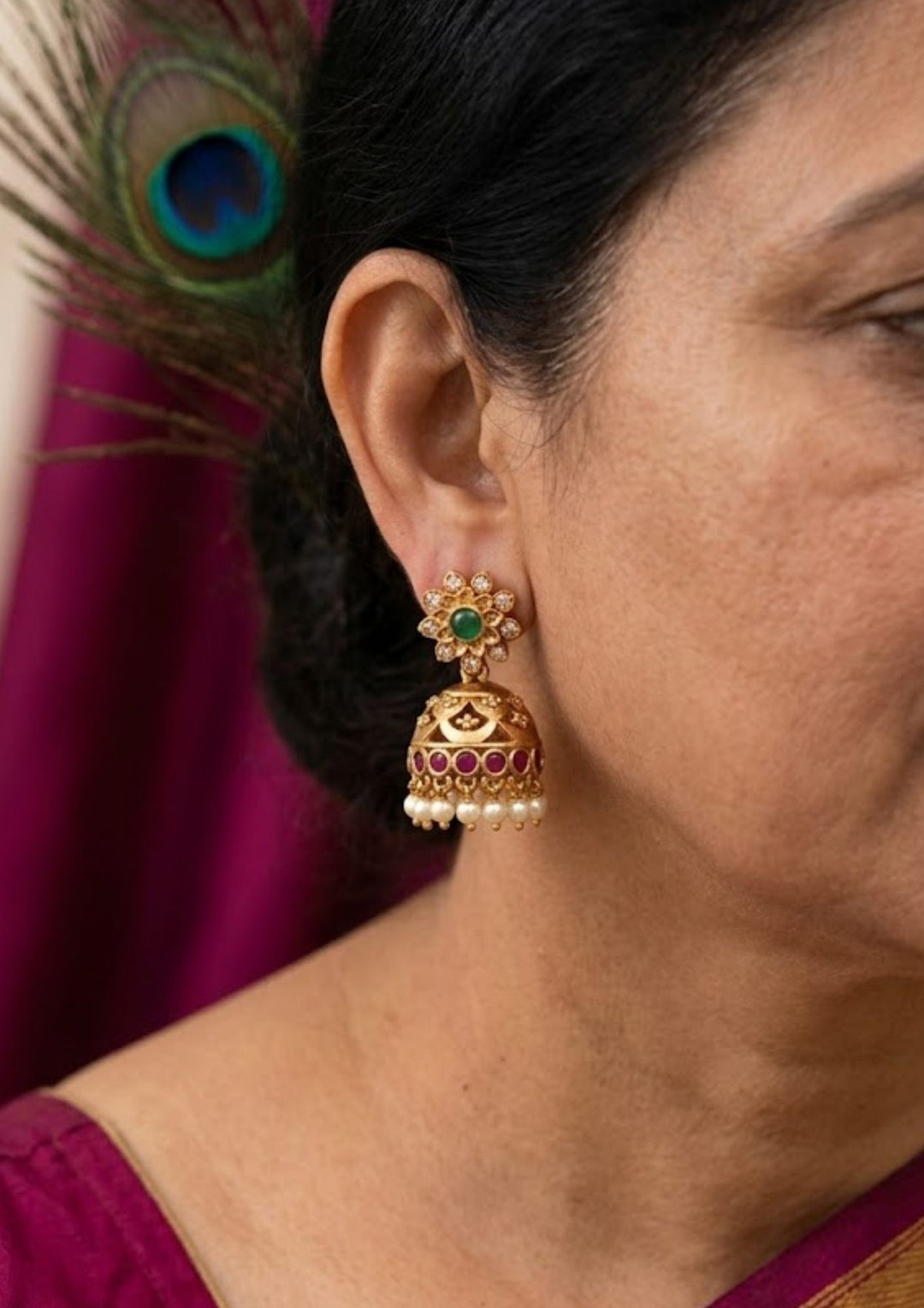 South Indian women wearing jadau kundan gold plated floral stud jhumka earrings designed with a green stone center, etched gold dome, and a fringe of white pearls that give a graceful traditional and modern look for weddings, festive occasions, poojas, and cultural styling with lightweight comfortable use and COD available now.