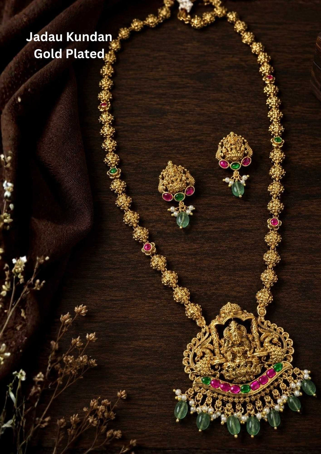 Gold-plated laxmi devi necklace set with intricate design long necklace Set and earrings with green and red stones come with jadau kundan in necklace set  with beads and in laxmi devi pendent and earrings shows clear design and temple jewelry in detailed shown in picture it will not fade color and water proof can used for festivals, bridals, and weeding's  