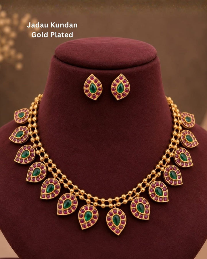 Woman wearing a gold necklace with red gemstones 