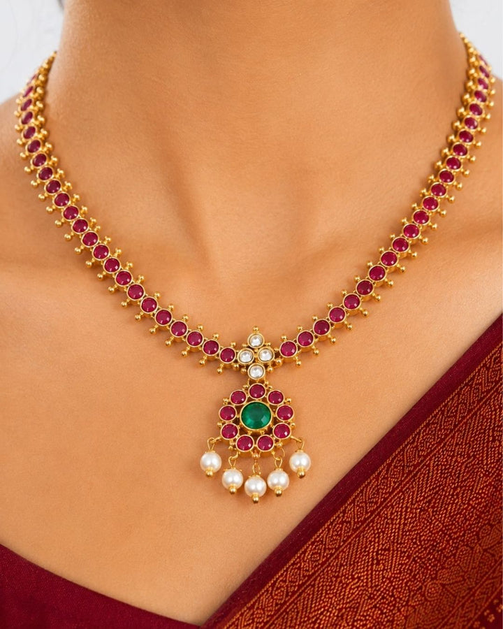 Beautiful Jadau Kundan gold plated necklace set featuring a ruby and green stone design, detailed Kundan work, and delicate pearl drops. Perfect for festive occasions, traditional outfits, weddings, parties, and gifting.