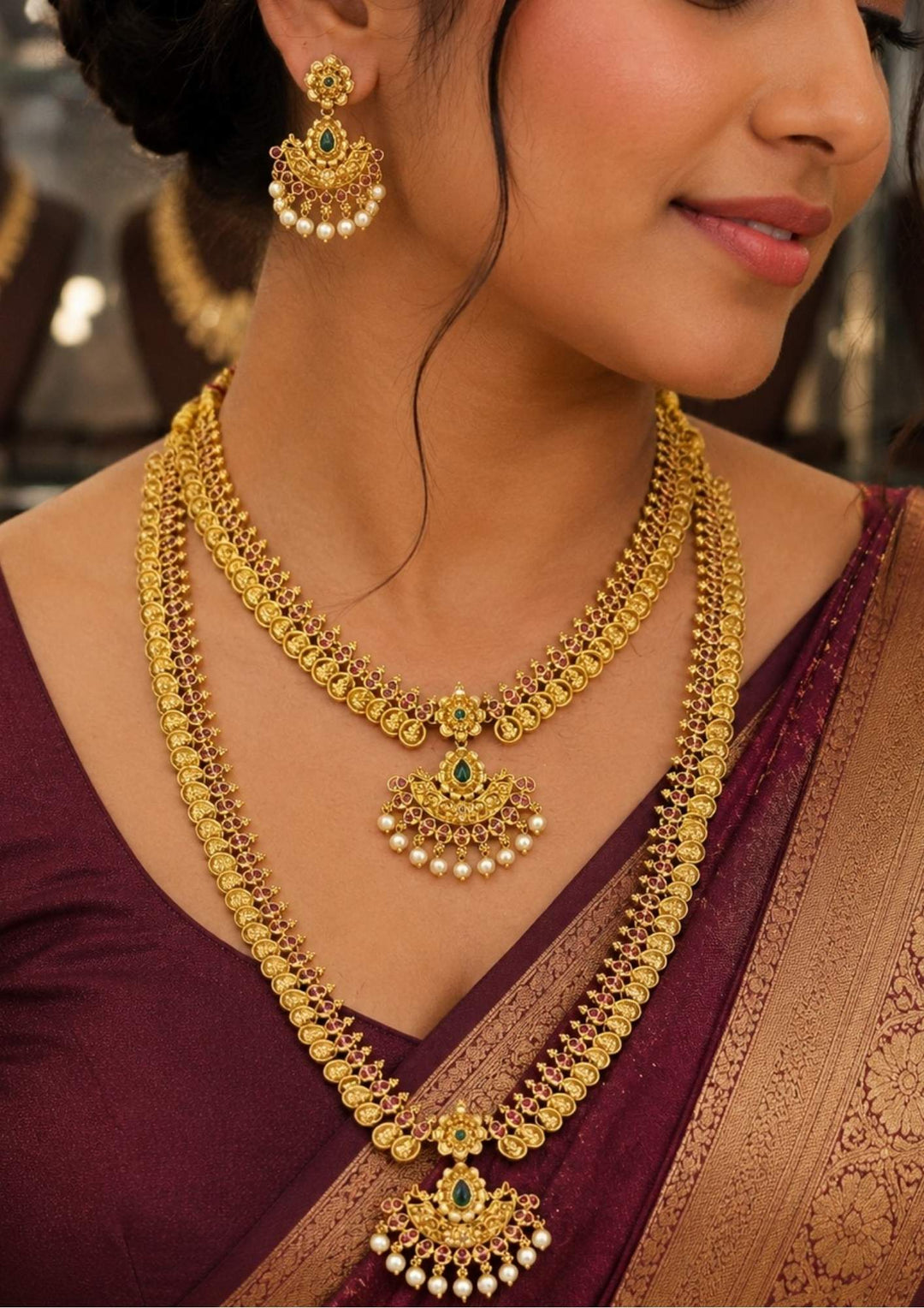 A close-up of a south indian woman wearing Luxurious Jadau Kundan gold plated bridal necklace set featuring layered long harams, matching earrings, green stone accents, and pearl dangles. Perfectly crafted for bridal wear, weddings, receptions, and grand festive occasions.