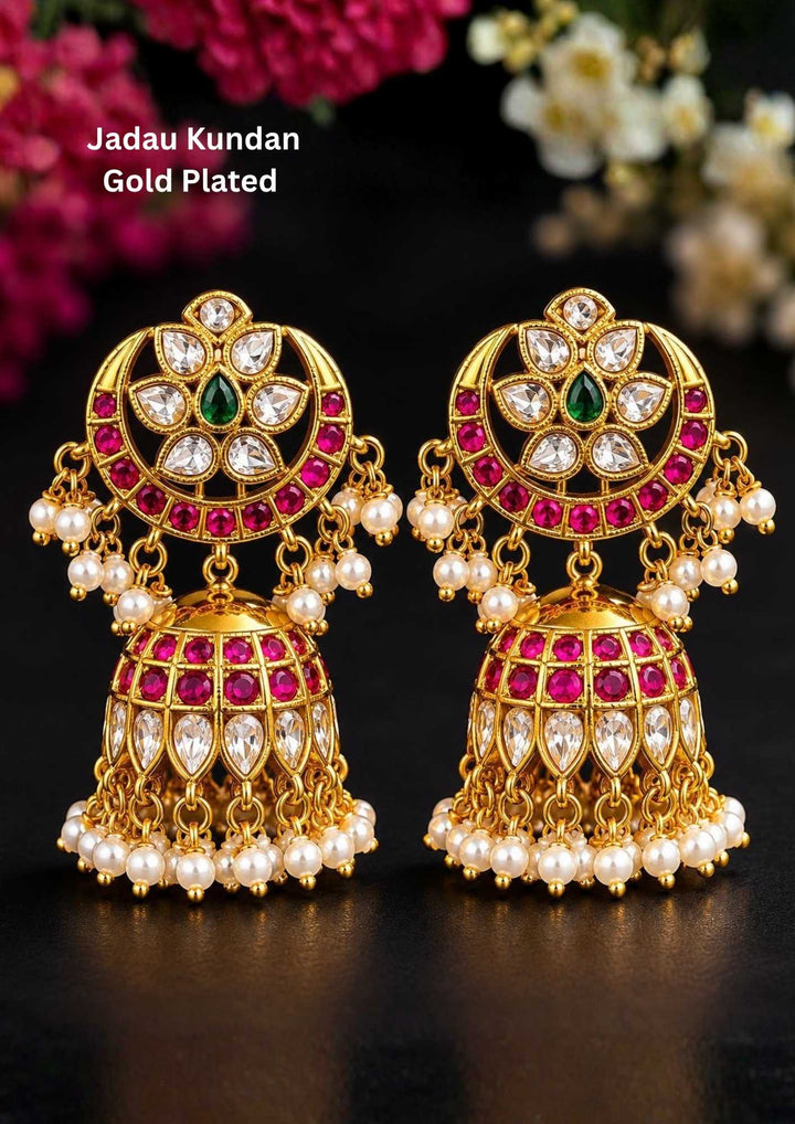 Jadau Kundan gold plated jhumka earrings with detailed white kundan stones, ruby pink round stones, green center stone accents and hanging pearl drops in antique traditional design.  suitable for weddings, bridal wear, poojas, festivals, Bharatanatyam, temple functions, sarees and lehengas with lightweight comfortable fitting, anti fade polish, skin friendly quality