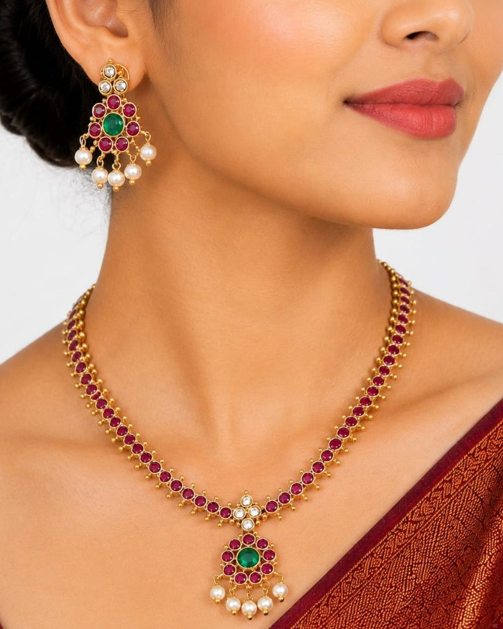 Beautiful Jadau Kundan gold plated necklace set featuring a ruby and green stone design, detailed Kundan work, and delicate pearl drops. Perfect for festive occasions, traditional outfits, weddings, parties, and gifting.
