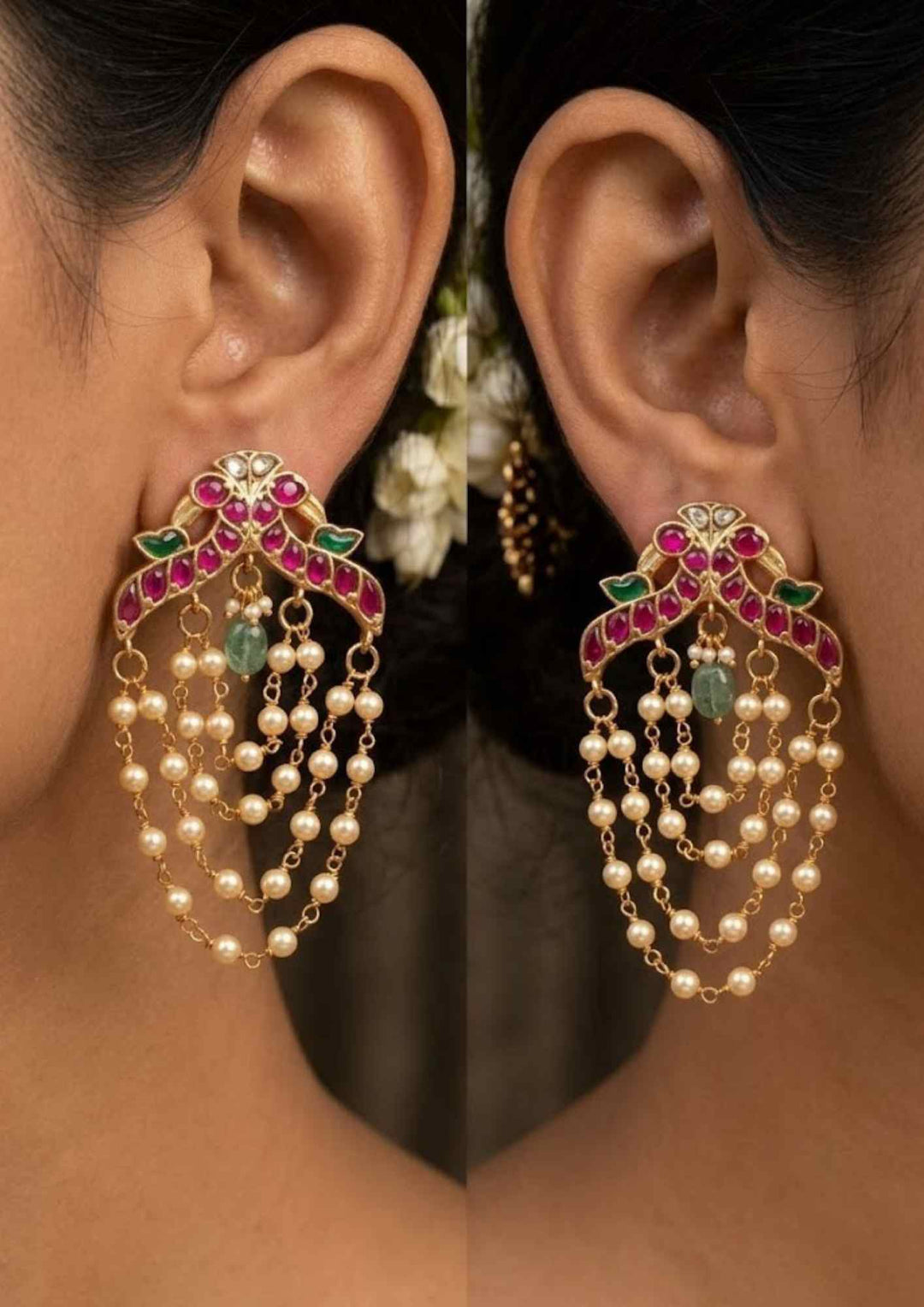 Close up of a women wearing Traditional style gold plated Jadau crescent chandbali earrings designed with screwback stems, vibrant pink-green stone layouts, and four hanging layers of micro pearl chains that give a graceful traditional look for festive celebrations, poojas, family functions, and bridal outfits.