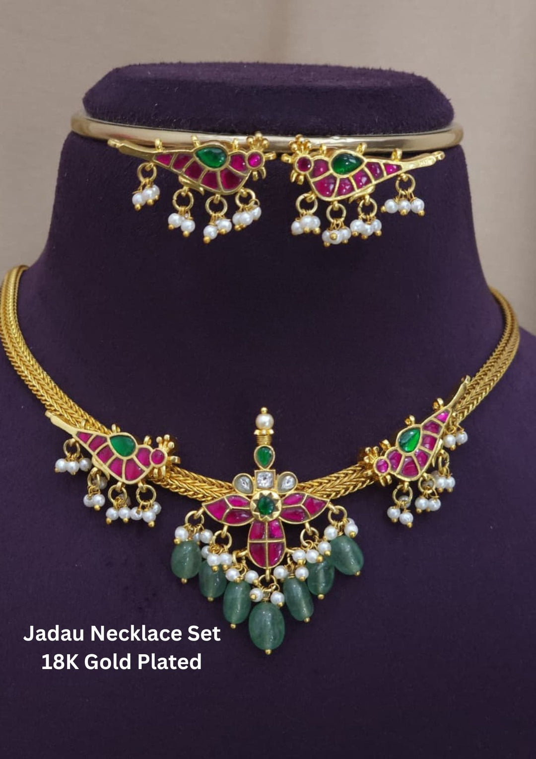 Jadau necklace set with gold, green, and red gemstones