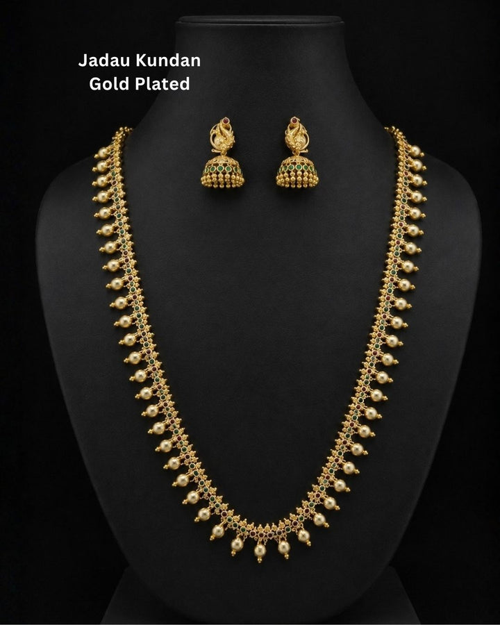 Beautiful gold plated necklace set featuring intricate green and ruby stonework, delicate pearl drop embellishments, and matching peacock-inspired jhumka earrings. Perfect for weddings, bridal wear, festive occasions, traditional outfits, parties, and gifting.