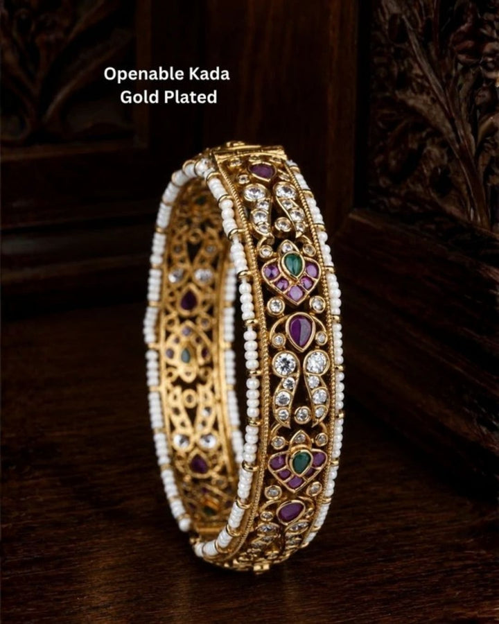 Beautiful Jadau Kundan gold plated openable kada adorned with ruby, green stones, dazzling Kundan work, and pearl detailing. Perfect for weddings, festive occasions, traditional wear, and premium gifting.