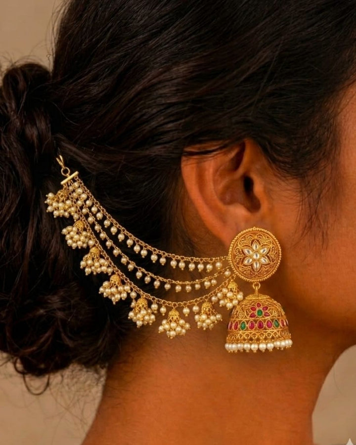 Traditional gold plated pearl ear chains featuring three layered chains with clusters of white pearls and intricate gold motifs, perfect for bridal and festive occasions.