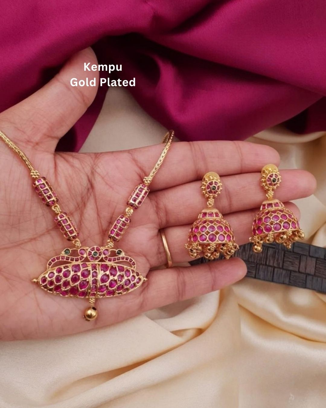Premium gold plated ruby stone choker necklace set featuring an intricate central floral-inspired pendant and matching jhumka earrings embellished with ruby-colored stones. Perfect for weddings, festive occasions, traditional wear, parties, and gifting.