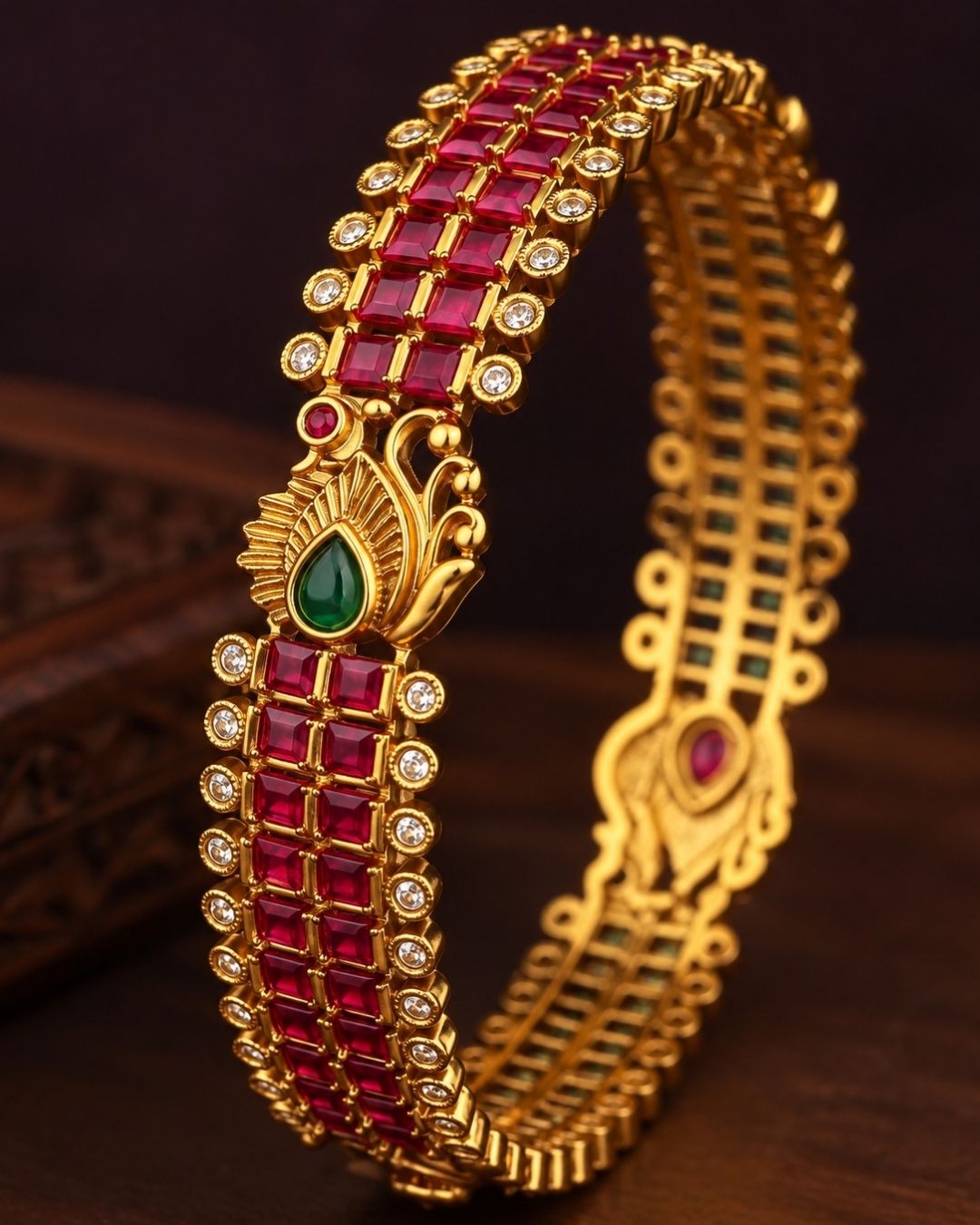 Premium gold-plated real Kemp peacock bangles designed with multiple rows of square-cut red Kemp stones, with white crystal borders, and an ornate golden peacock design centered with a water drop green stone. It is lightweight, skin-friendly, and anti-fade bangles are perfect for poojas, festive wear, and dailywear.