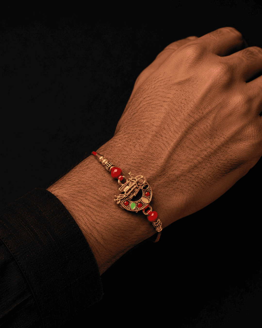 Beautiful gold plated Krishna Rakhi featuring a divine Lord Krishna design with flute, decorative red beads, and premium craftsmanship. Perfect for Raksha Bandhan gifting.