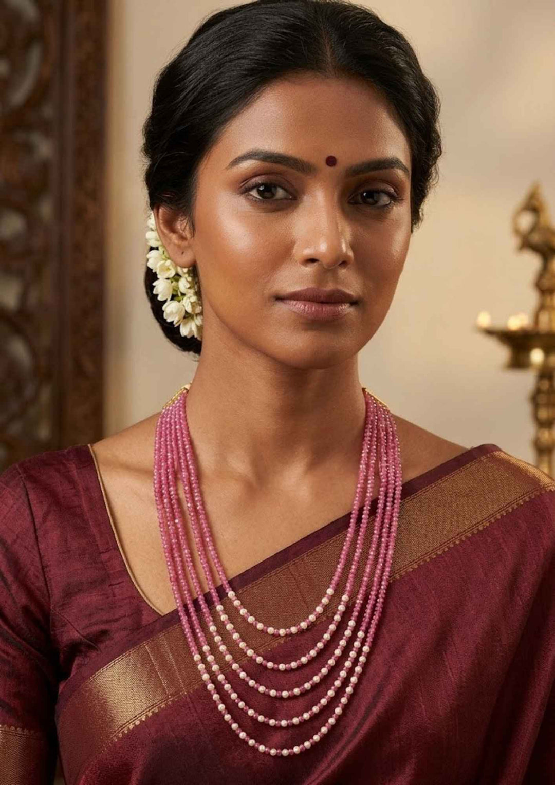 Close-up of south indian women wearing a kundan beads 18k gold plated multi strand ruby pink layering haram on a display bust showing the alternating pearl accents that give a graceful traditional and modern look for family celebrations with COD.