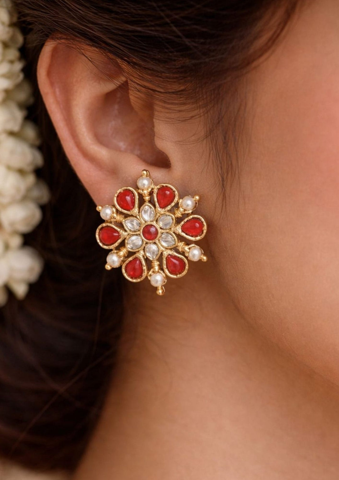 South indian women wearing a Traditional coral jhumkas gold plated screwback earrings The earrings are adorned with vibrant coral red bead danglers and detailed antique gold finish patterns, creating a rich South Indian ethnic look suitable for weddings, festivals, poojas and cultural celebrations