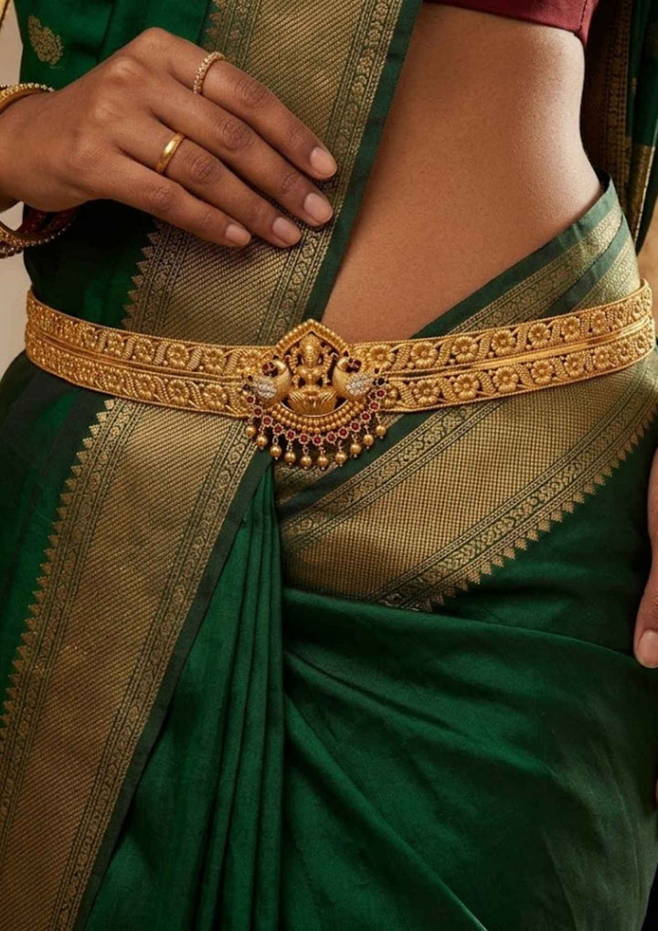 South indian women wearing gold plated Laxmidevi twin peacock heritage adult hipbelt vaddanam resting on velvet showing ruby bead accents that give a graceful traditional and modern look for South Indian brides with COD.