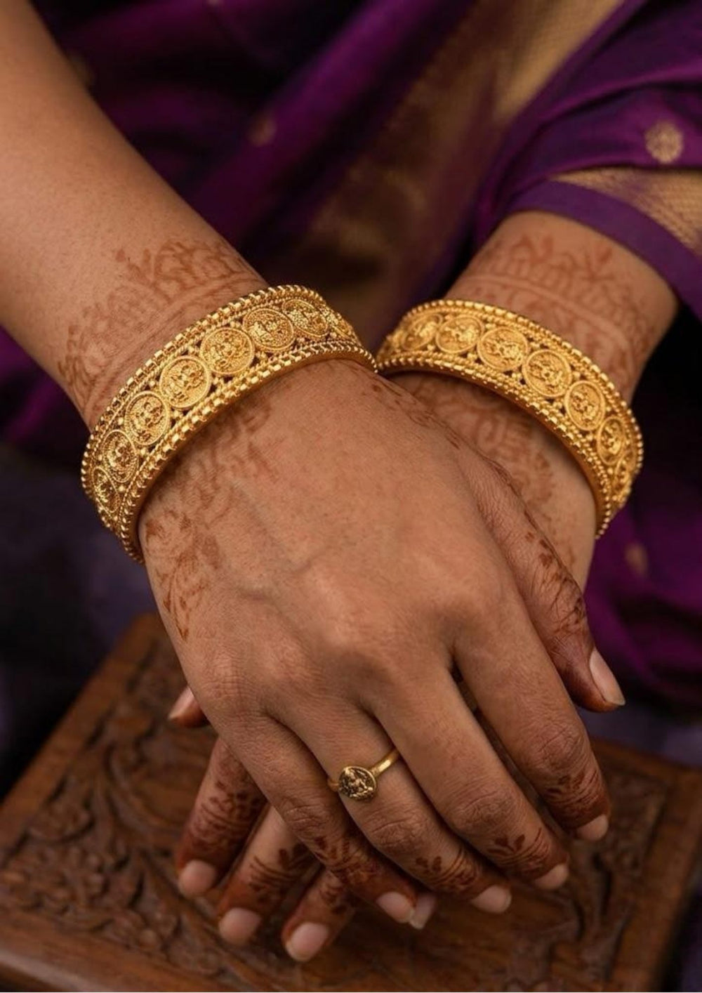 Close-up of a south Indian woman wearing Laxmi Kasula Bangles with traditional Lakshmi coin designs showing Goddess Lakshmi sitting on a lotus flower. The bangles give a rich traditional gold jewelry look with shiny finish, lightweight comfort, sweat proof quality, anti-fade colour, skin-friendly finish, and are suitable for weddings, festivals, functions, celebrations, and weddings.