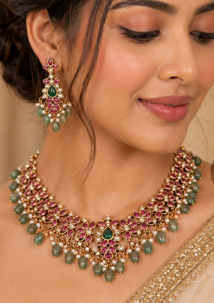 South indian women wearing Traditional style 18K gold plated Jadau choker necklace set designed with a red stone border band, sparkling kundan outlines, a central crescent pendant, and rows of hanging white pearl drops that give a graceful traditional look for festive celebrations, poojas, family functions, and bridal outfits.