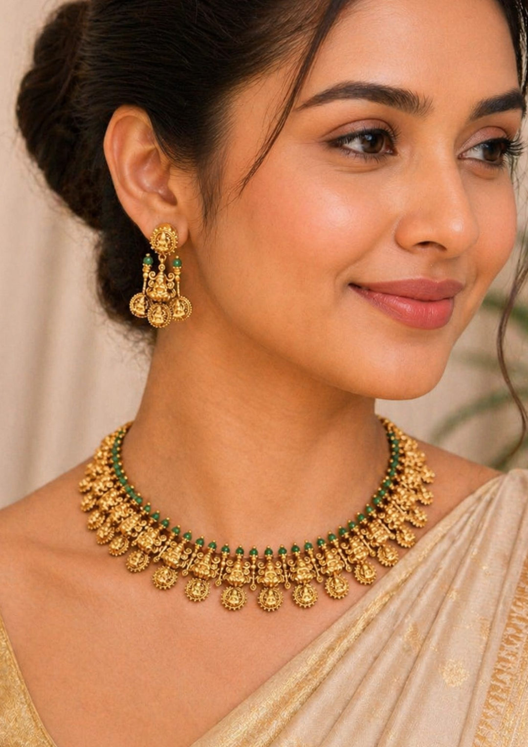 South indian women wearing Traditional style gold plated temple long haram necklace designed with structured Nakshi panels of Goddess Laxmi, green bead accents, and an elegant matte gold finish that gives a graceful traditional look for festive celebrations, poojas, family functions, and bridal outfits.