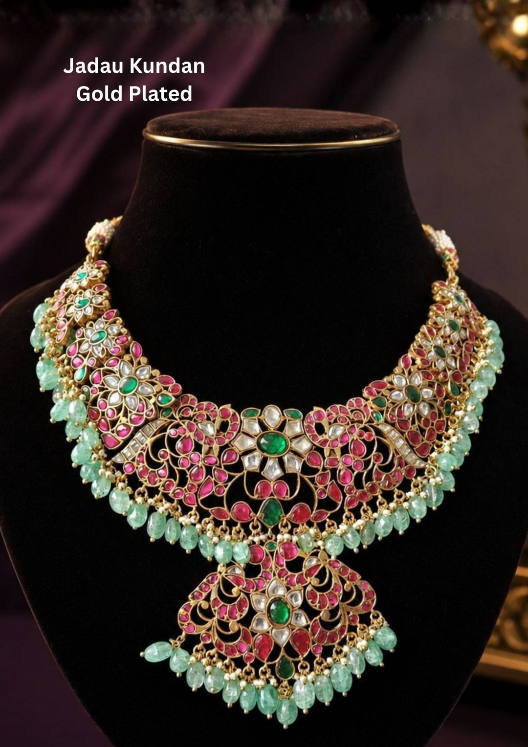 A grand and heavy 18k gold plated traditional bridal choker necklace featuring an extensive, intricate openwork web of floral and paisley motifs. The entire collar is heavily encrusted with rich ruby-pink stones, emerald-green centers, and uncut white crystals, beautifully finished with an elaborate, dense lower fringe of dangling mint-green beads perfect for weddings, bridal wear, functions. it is anti fade color and skin friendly