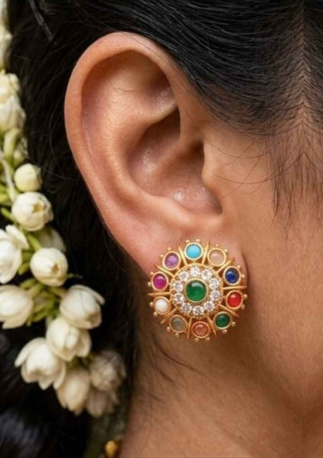 Close-up of an ear wearing a colorful earring in south indian traditional look  gold plated can be used for  flat detail for functional, festive , south indian festival 