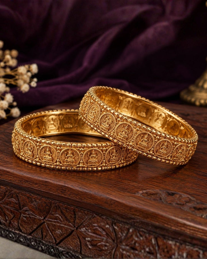 Close-up of a south Indian woman wearing Laxmi Kasula Bangles with traditional Lakshmi coin designs showing Goddess Lakshmi sitting on a lotus flower. The bangles give a rich traditional gold jewelry look with shiny finish, lightweight comfort, sweat proof quality, anti-fade colour, skin-friendly finish, and are suitable for weddings, festivals, functions, celebrations, and weddings.