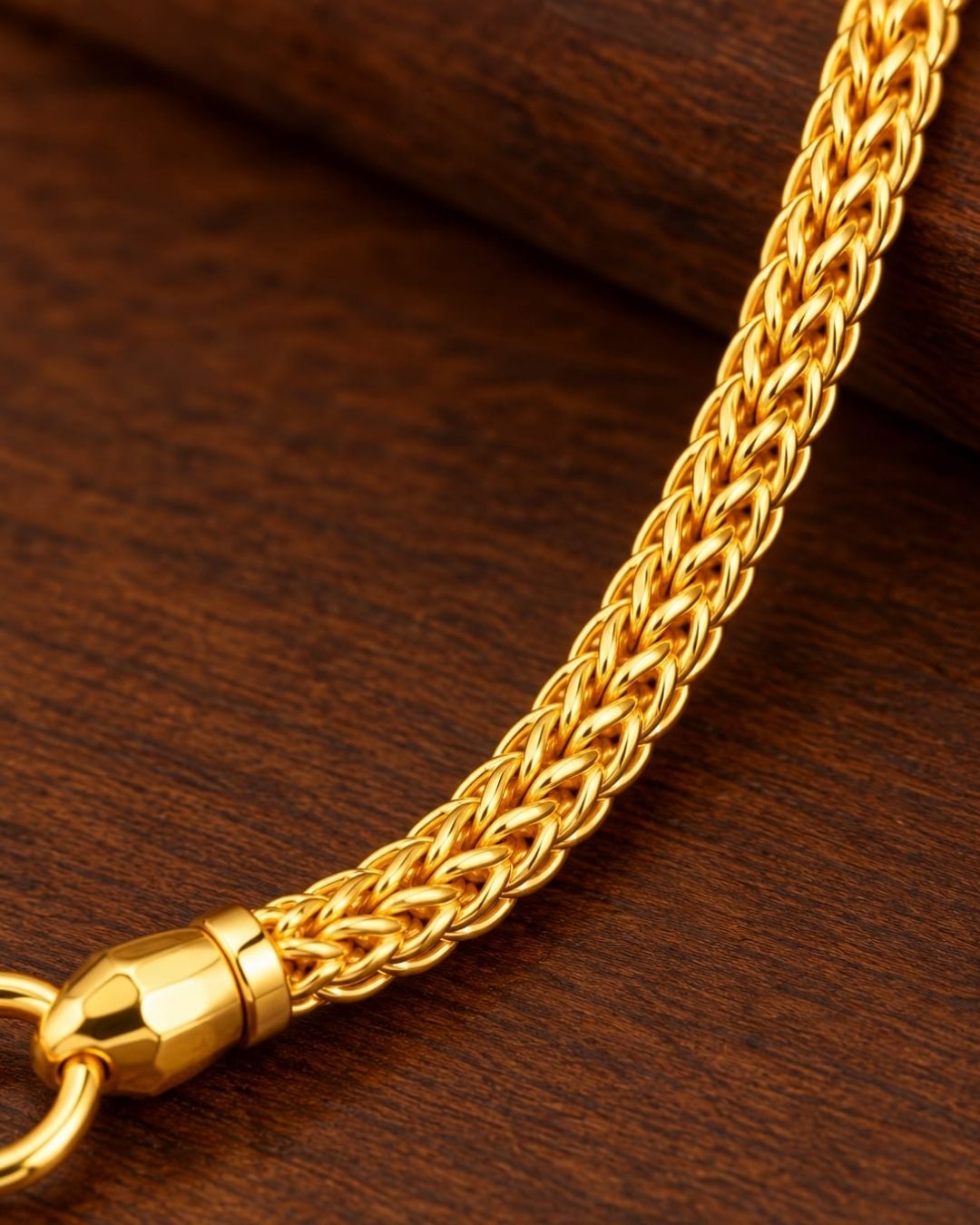 Gold plated thaali chain displayed on a dark wooden surface, highlighting its delicate links and traditional Lakshmi Devi design.