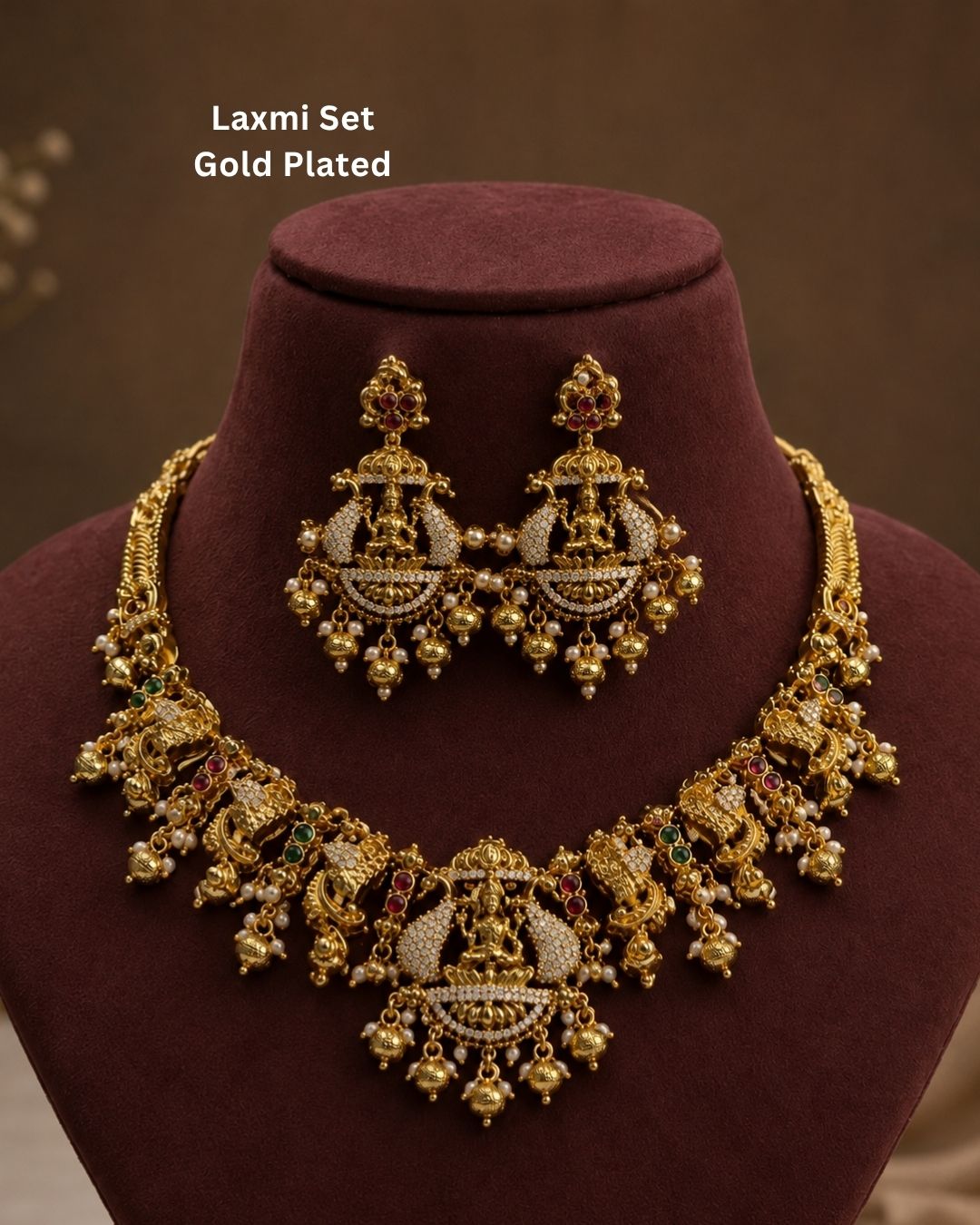 Elegant gold plated bridal temple necklace and earrings set adorned with Goddess Lakshmi motifs, shimmering CZ stones, pearl hangings, and intricate handcrafted detailing.