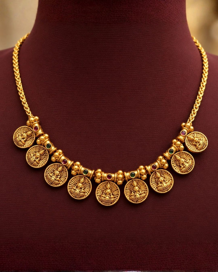 Antique gold plated South Indian coin necklace set with Goddess Lakshmi motifs and matching earrings for festive and traditional wear.