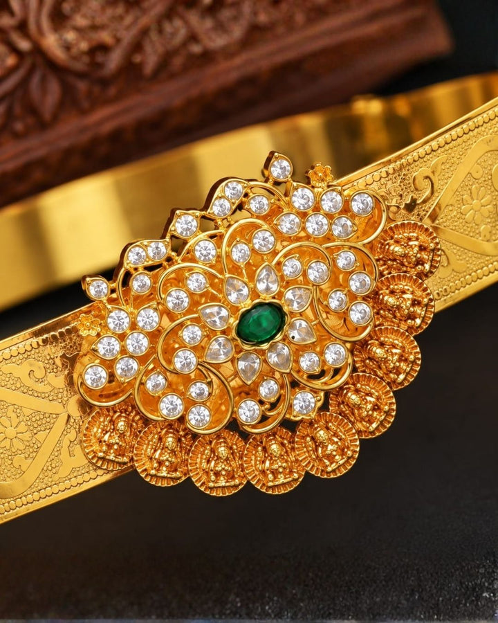 Elegant gold plated vaddanam with a floral crystal centerpiece and intricate detailing for festive and traditional wear.