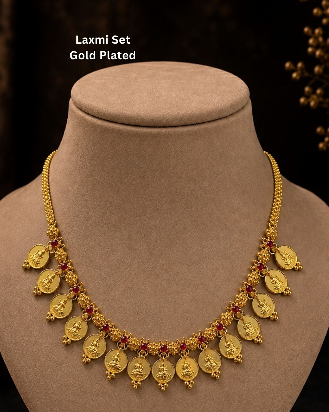 Exquisite Goddess Laxmi gold-plated coin necklace featuring intricate motif carvings and ruby-colored stone accents. Ideal for weddings, festive occasions, temple visits, traditional sarees, and bridal gifting.