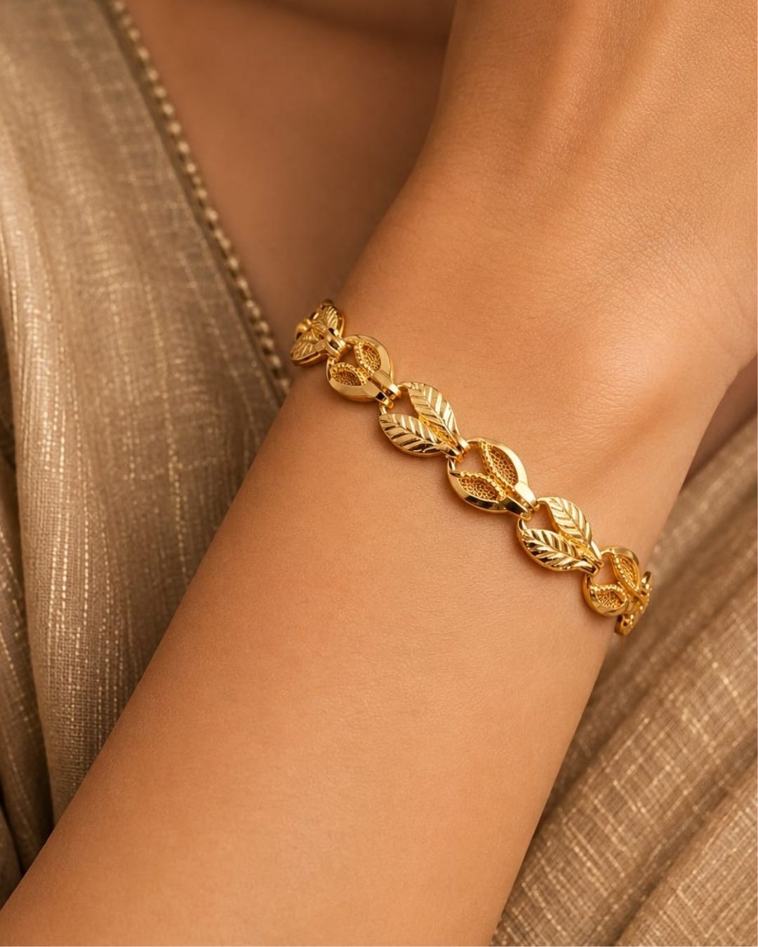 Beautiful gold plated bracelet featuring repeating leaf-shaped links with detailed vein patterns and polished connecting elements. Perfect for traditional wear, festive occasions, daily wear, and gifting.