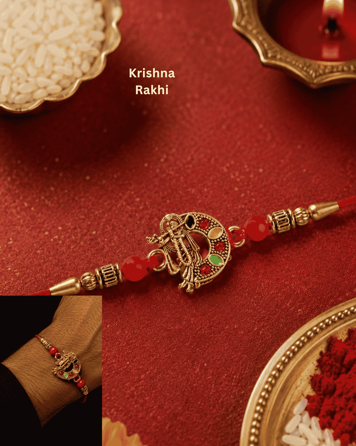 Beautiful gold plated Krishna Rakhi featuring a divine Lord Krishna design with flute, decorative red beads, and premium craftsmanship. Perfect for Raksha Bandhan gifting.